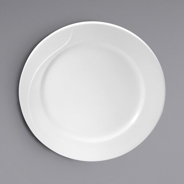 A close-up of an embossed white Oneida Eclipse bone china plate with a curved edge.
