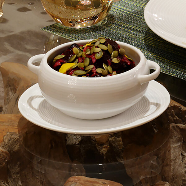 A bowl of food on a white Front of the House Spiral porcelain plate.