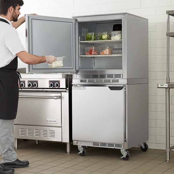 A man opening the left door of a white Beverage-Air undercounter refrigerator.