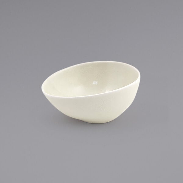 A Front of the House vanilla bean porcelain ramekin on a gray surface.