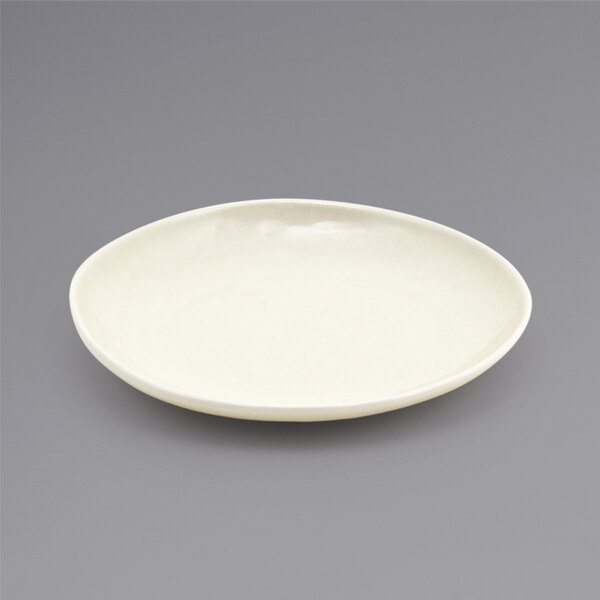 A white Front of the House porcelain plate with a small rim on a gray background.