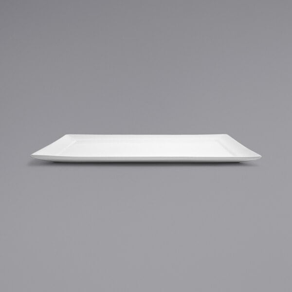 A white rectangular Front of the House Spiral porcelain plate on a grey background.