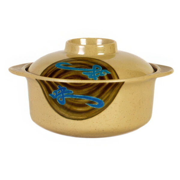 A beige melamine bowl with blue and brown designs on the counter.