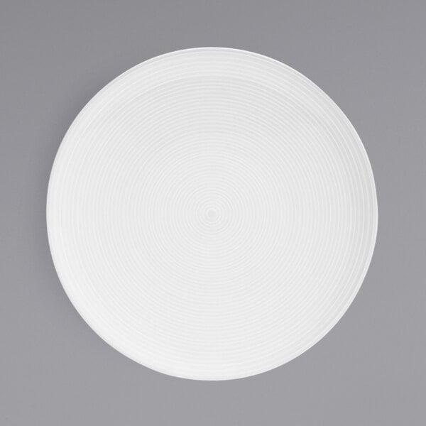 A white porcelain plate with spiral lines on it.