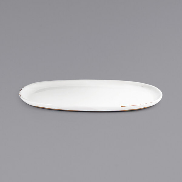 A white oval porcelain plate with a brown trim.