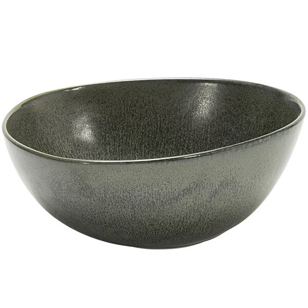 A close up of a sage green porcelain bowl with a speckled surface and black rim.