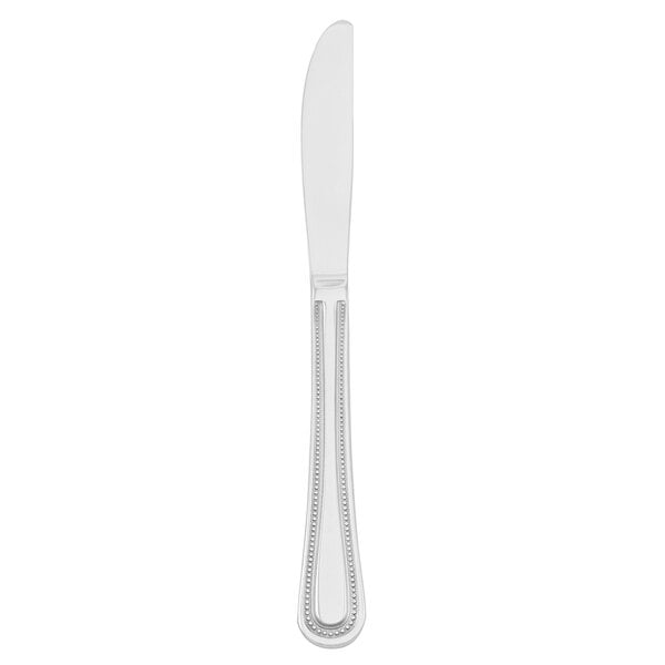A silver stainless steel dinner knife with a white handle.