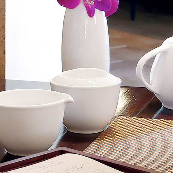 A white porcelain sugar pot with a spiral design on it.