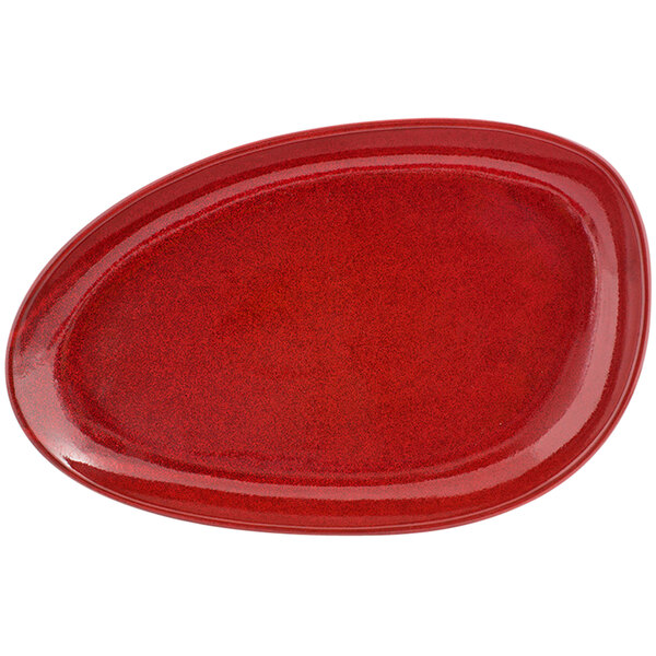 A white porcelain oval plate with red chili designs on the rim and center.