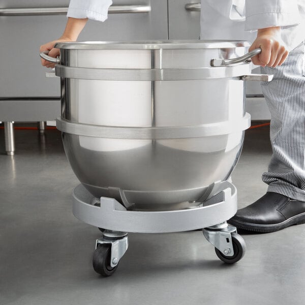 a hand holding a large metal pot