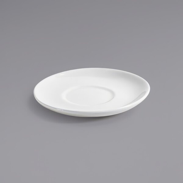 A white Front of the House Kiln porcelain saucer on a gray surface.