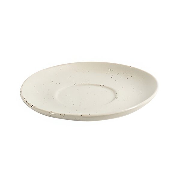 A white porcelain saucer with specks on it.