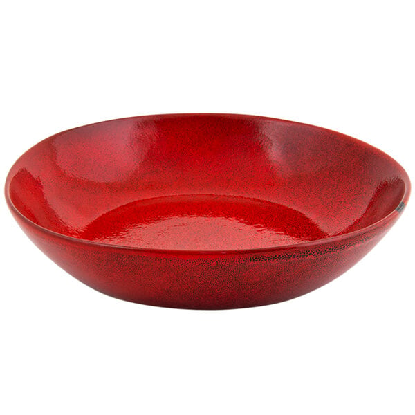 A red bowl with a shiny surface and black specks.