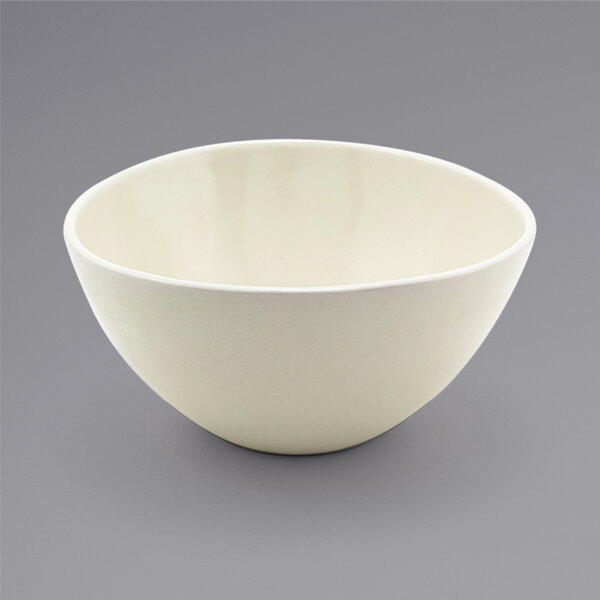 A white Front of the House Kiln oval tall porcelain bowl on a gray surface.