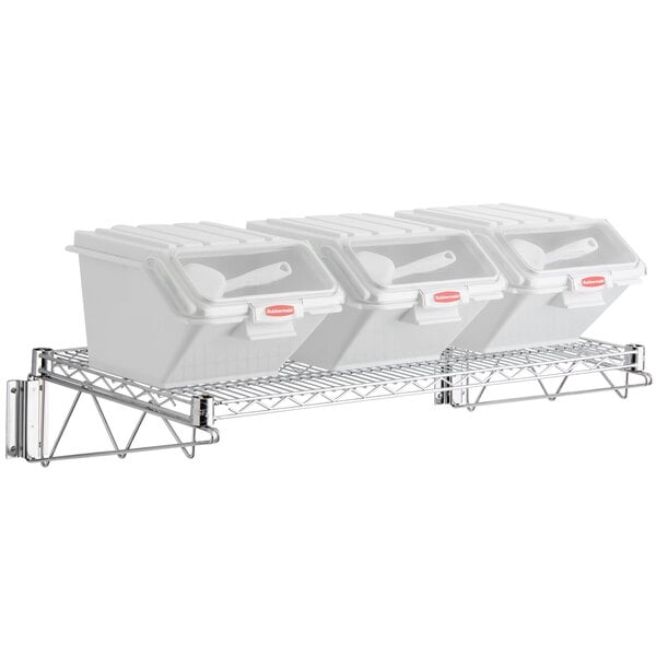 A Rubbermaid metal wall mounted shelving kit with 3 white ingredient bins on it.