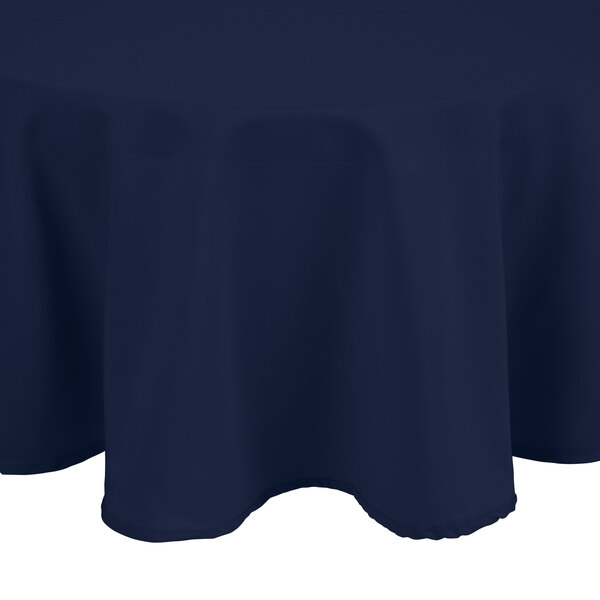 A navy blue Intedge round tablecloth on a table.