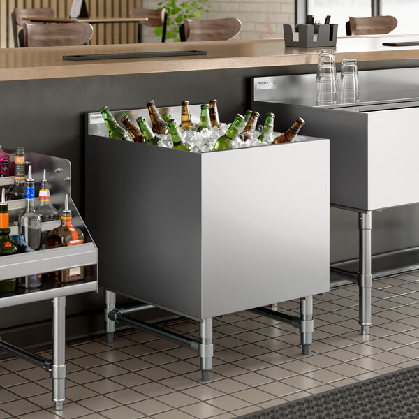 A stainless steel beer box filled with ice and bottled beverages, designed for bar use.