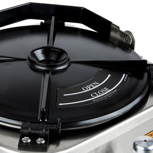 A stainless steel Grindmaster coffee shuttle with a lid on top on a table.