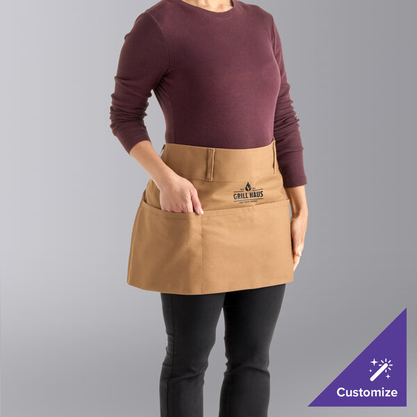 A caramel-colored cotton waist apron with natural webbing and three pockets, customizable with a logo.