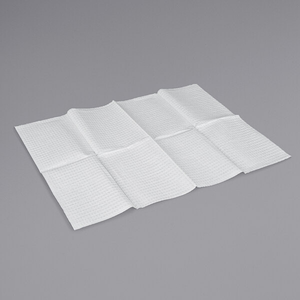 A folded white Koala Kare baby changing table bed liner on a gray surface.