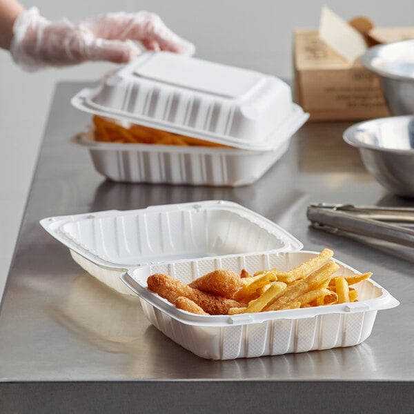 A Dart white plastic takeout container with food in it.