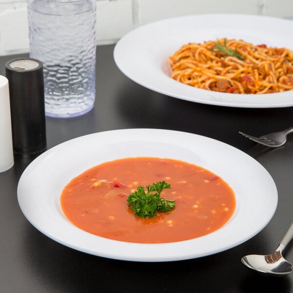 A white Carlisle melamine bowl filled with soup on a table.