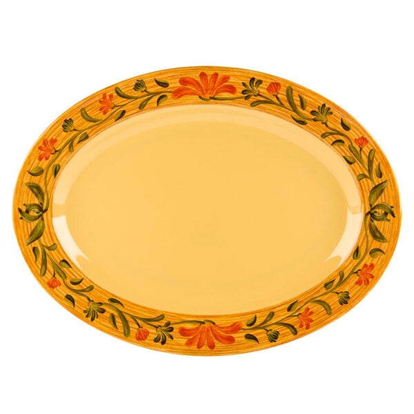 A white oval platter with a yellow and green floral design.