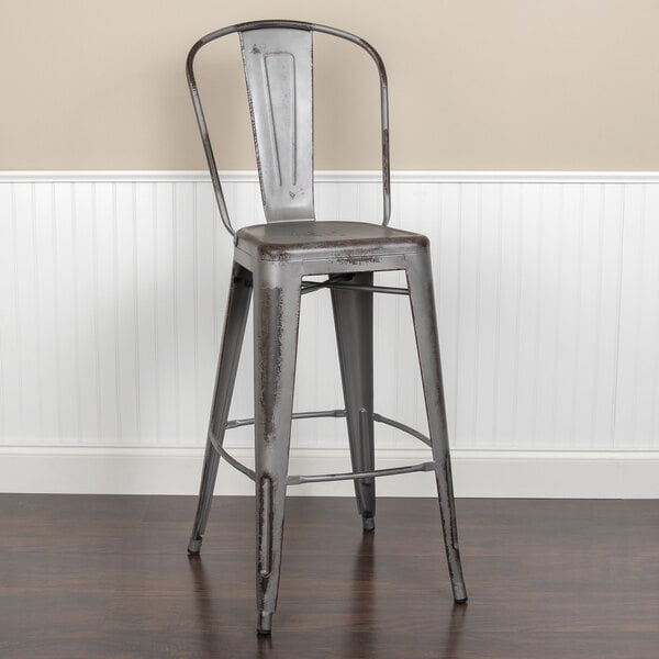 A Flash Furniture metal bar stool with a vertical slat back and drain hole seat.