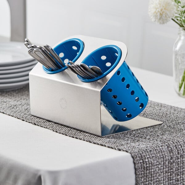 A Steril-Sil stainless steel flatware organizer with blue perforated plastic cylinders holding silverware.