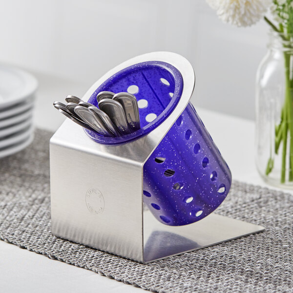 A Steril-Sil stainless steel flatware organizer with a purple plastic cylinder holding silverware.