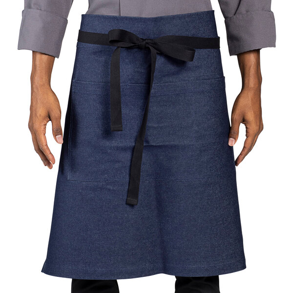 A man wearing a Uncommon Chef indigo denim apron with black webbing.