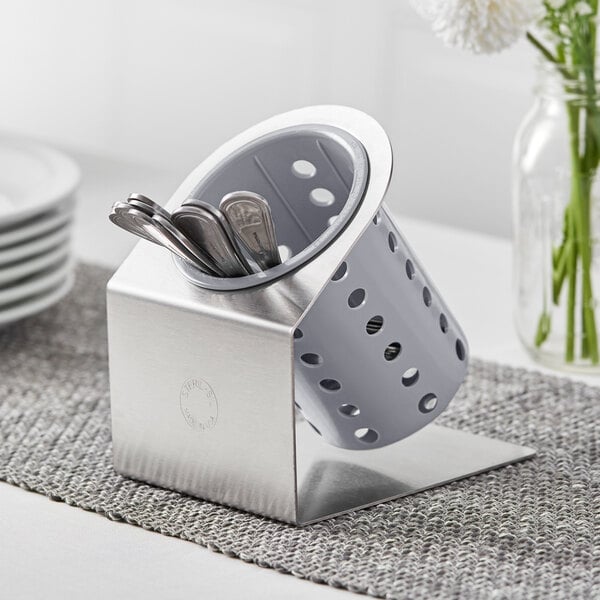 A Steril-Sil stainless steel flatware organizer with gray plastic cylinder holding silver spoons.