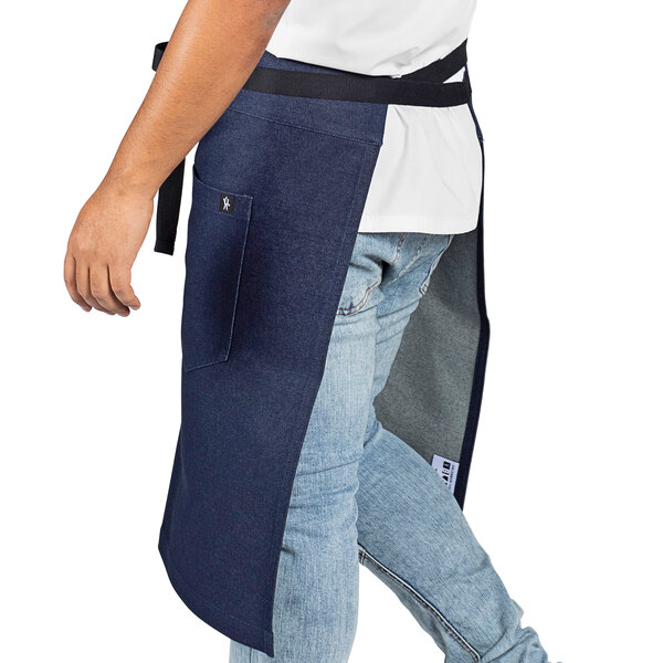 A man wearing a customizable blue denim Uncommon Chef apron with black webbing.