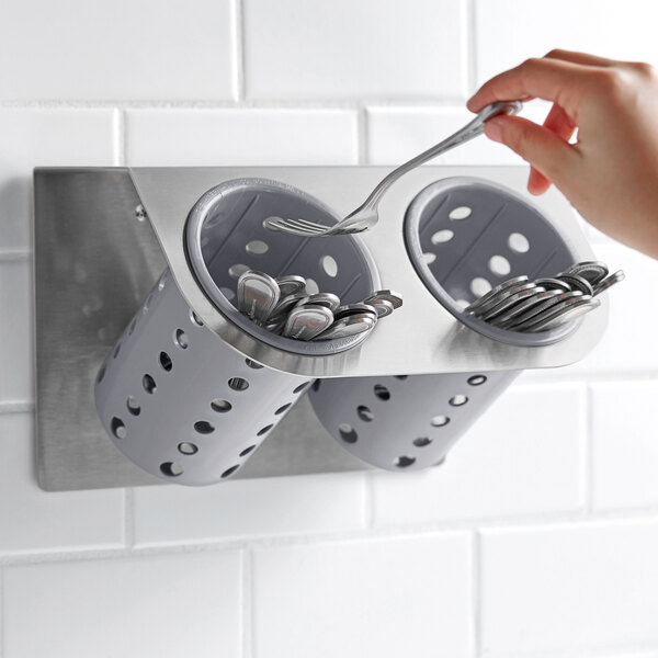 a hand holding a container of silver coins