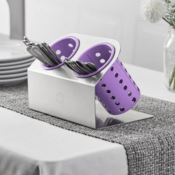 A silver and purple Steril-Sil flatware organizer with violet plastic cylinders holding utensils.