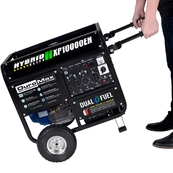 A man pushing a DuroMax portable generator on wheels.