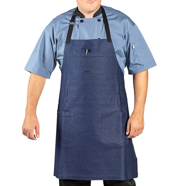 A man wearing a Uncommon Chef indigo denim bib apron with black webbing.