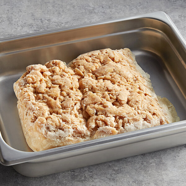 Sliced Original Philly Cheesesteak Co. chicken steak in a metal pan on a counter.