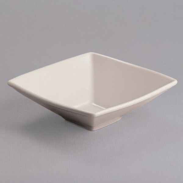 A white square bowl with a square shape on a gray surface.