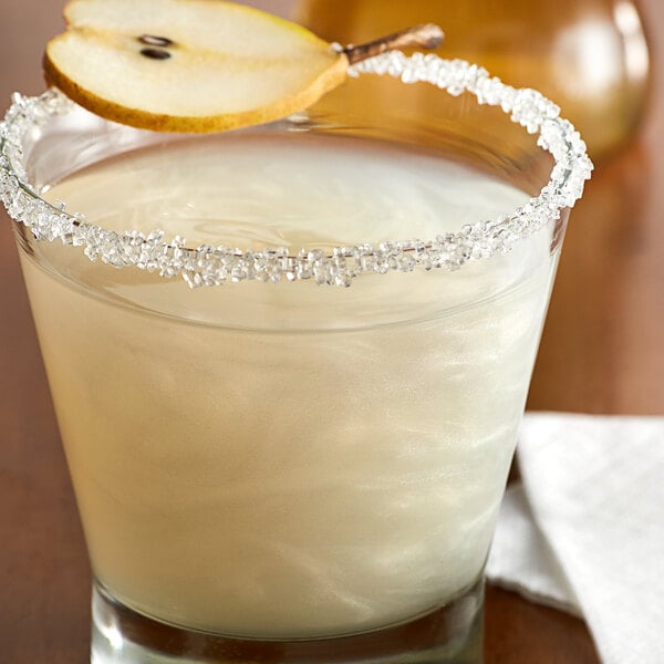 A glass of liquid with a Spirdust Silver Pearl garnished pear slice.