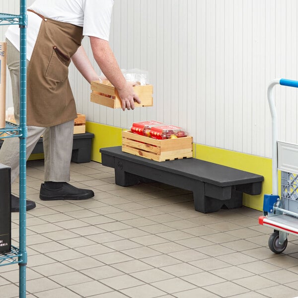A man in an apron standing next to a Regency narrow dunnage rack.