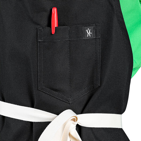 A black Uncommon Chef bib apron with natural webbing and 3 pockets.