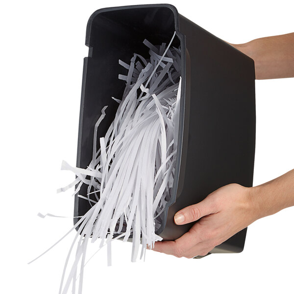a hand holding a paper shredder