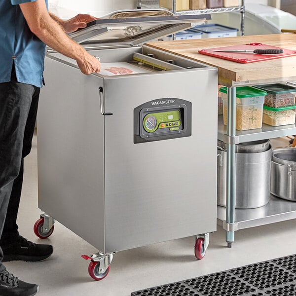 A stainless steel VacMaster VP545 floor model chamber vacuum packaging machine with two 20-inch seal bars on red caster wheels.