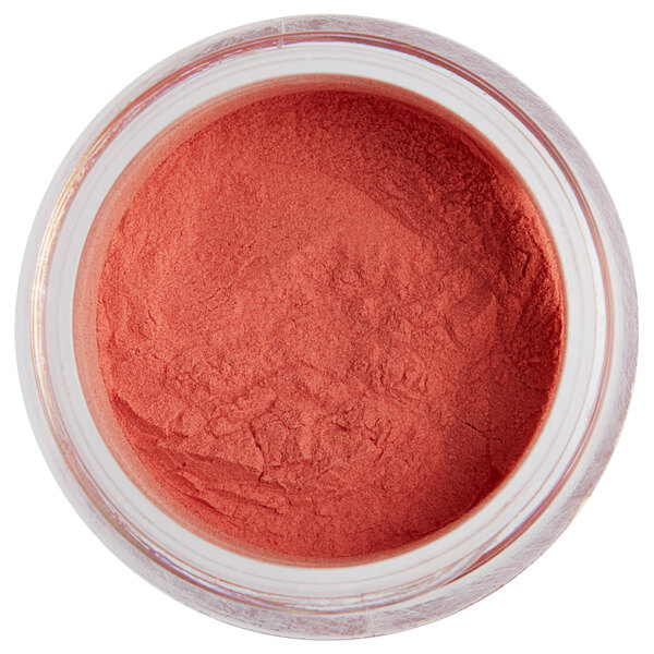 A jar of neon orange powder with a white label.