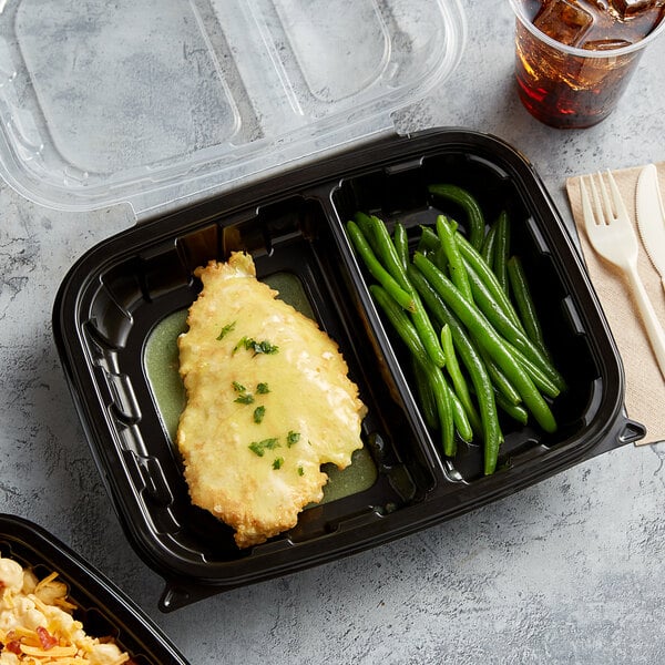 A microwaveable plastic hinged container with chicken, green beans, and fries.