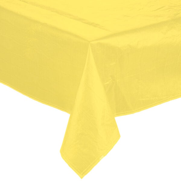 A yellow vinyl table cover with flannel back on a table.