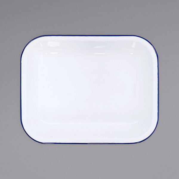 A white enamel roasting pan with a blue rim.