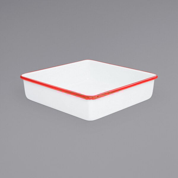 A white square enamel cake pan with red trim.