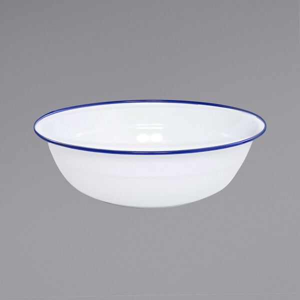 A white Crow Canyon Home enamelware basin with blue rolled rim.